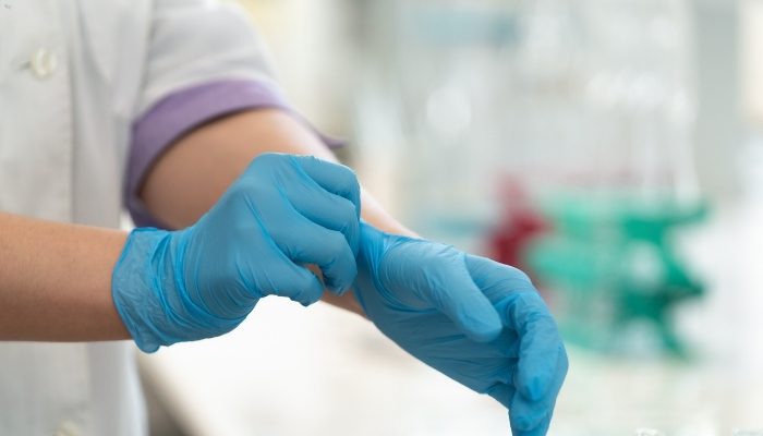 Doctor wearing medical gloves preparing for examination — representing GP duty of care and Jess’s Rule in preventing medical negligence.